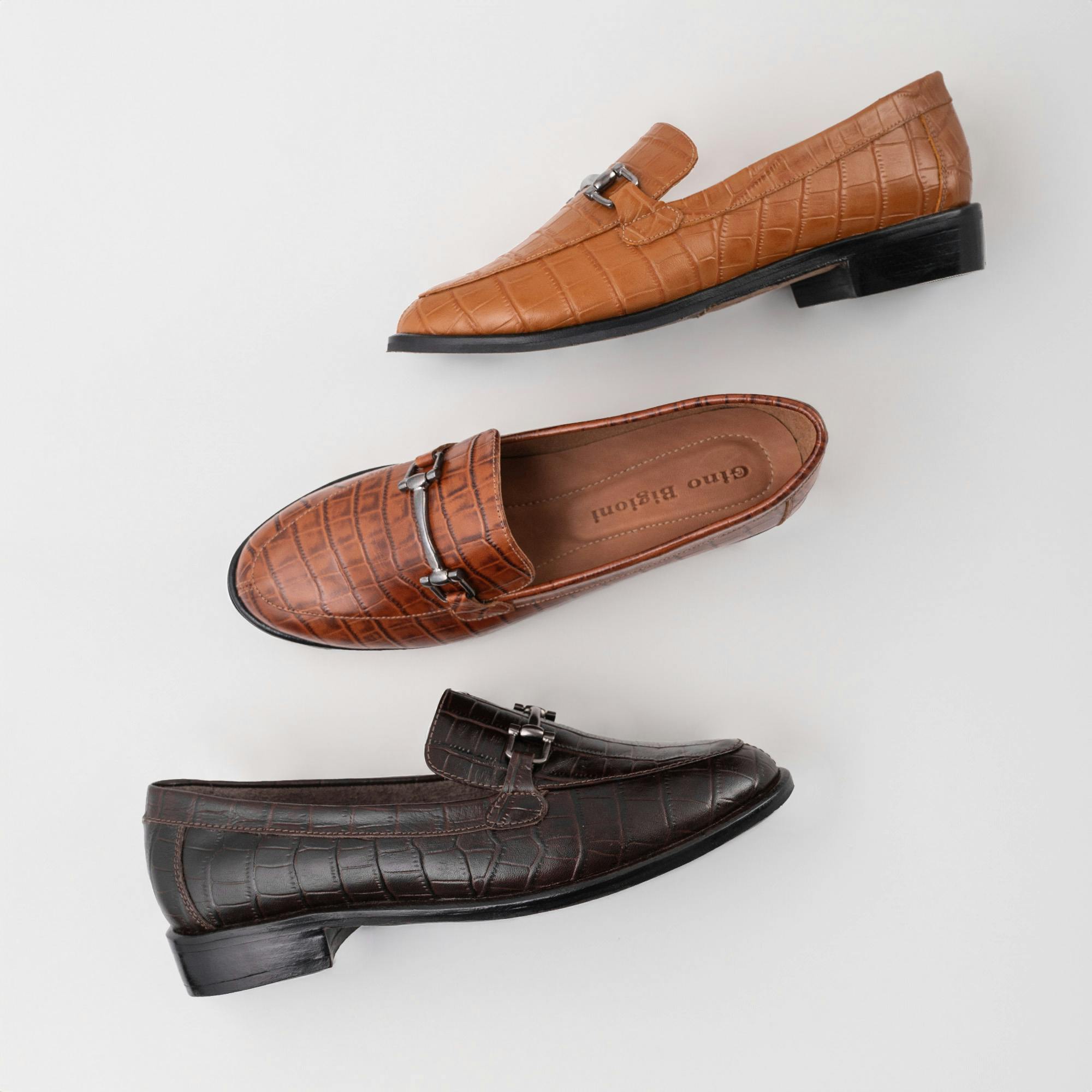 Croc-embossed leather loafers in brown shades showcased in a clean flat lay product photography style.